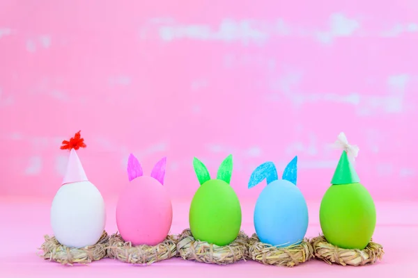 Enfoque suave de la fila huevos de Pascua con flores de papel de colores sobre fondo de madera de color rosa brillante y blanco . — Foto de Stock
