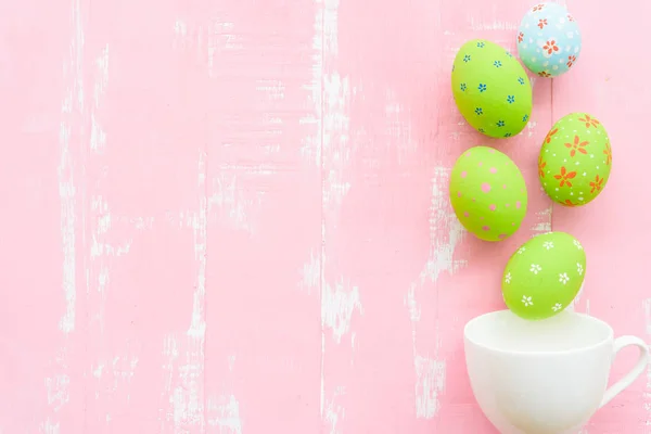 Frohe Ostern! Reihe bunter Ostereier aus weißer Tasse ausgebreitet — Stockfoto