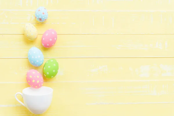 ¡Feliz Pascua! Fila coloridos huevos de Pascua esparcidos de la taza blanca —  Fotos de Stock