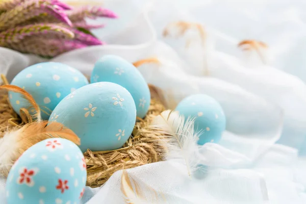 Счастливой Пасхи! Цветы пасхальных яиц в гнезде с цветами — стоковое фото