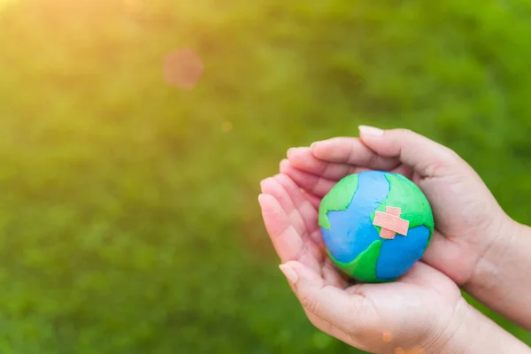 Världen Earth Day koncept. Kvinna hand innehav handgjorda globe — Stockfoto