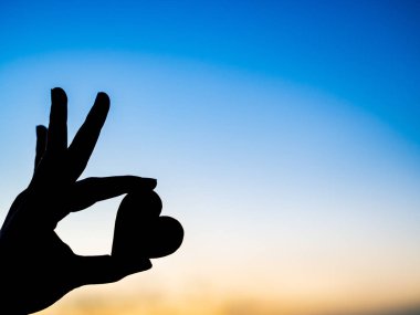 Siluet el sırasında günbatımı arka plan güzel kalp tutarak