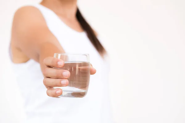 Een glas schoon mineraalwater in handen van de vrouw. — Stockfoto