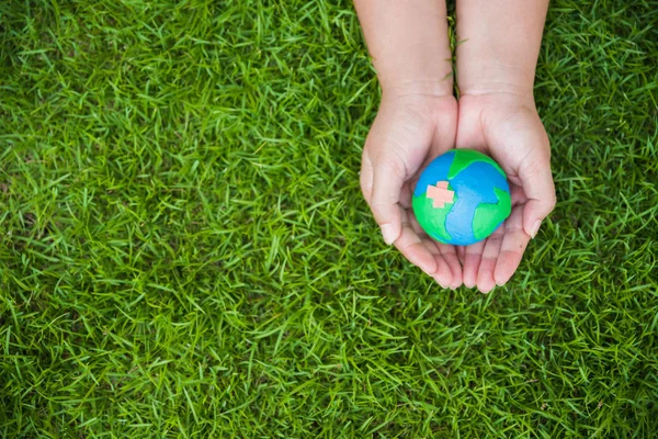 Världen Earth Day koncept. Kvinna hand innehav handgjorda globe — Stockfoto