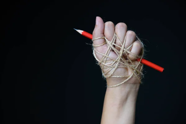 Hand with red pencil tied with rope — Stock Photo, Image