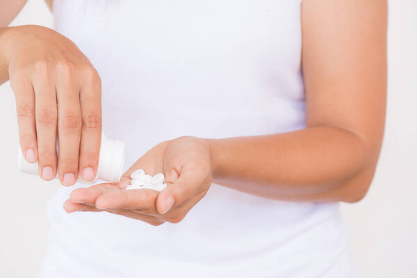 A young woman pours out medicine