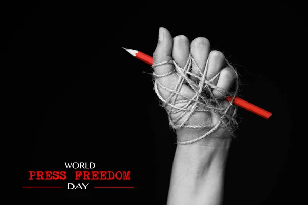 Hand med röd penna bundna med rep — Stockfoto