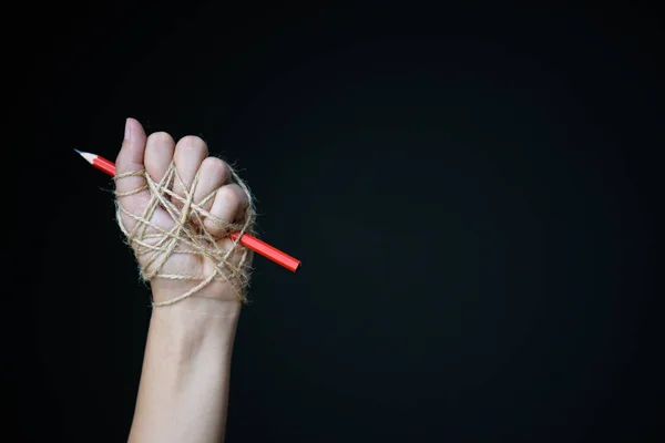 Hand with red pencil tied with rope — Stock Photo, Image