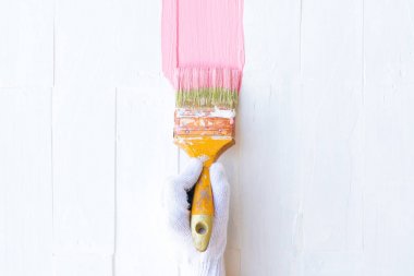 Kadın el fırça boya pembe rengi beyaz ahşap bir masa üzerinde tutarak yukarı kapatın