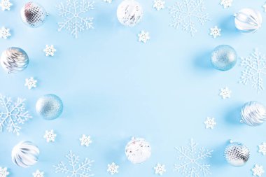 Noel konsepti. Açık mavi pastel arka planda kar taneleri olan Noel balosunun en üst görüntüsü.