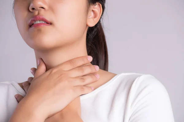 Mal di gola. Primo piano di bella giovane donna mano toccando il collo maligno. Concetto sanitario e medico. — Foto Stock