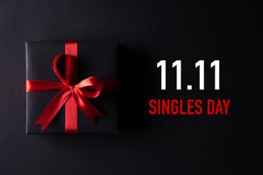 Çin 'de online alışveriş, 11.11 bekarlar günü konsepti. Siyah arkaplanda kırmızı kurdeleli siyah noel kutularının üst görünümü metin 11: 11 tekler için kopya alanı.