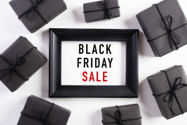 Siyah Cuma indirimli metnin beyaz çerçeveli, siyah hediye kutulu ve beyaz arka planda Noel balosu ve böğürtlenli hali. Alışveriş konsepti ve Kara Cuma kompozisyonu.