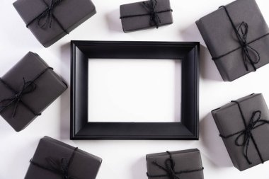 Siyah Cuma indirimli metnin beyaz çerçeveli, siyah hediye kutulu ve beyaz arka planda Noel balosu ve böğürtlenli hali. Alışveriş konsepti ve Kara Cuma kompozisyonu.