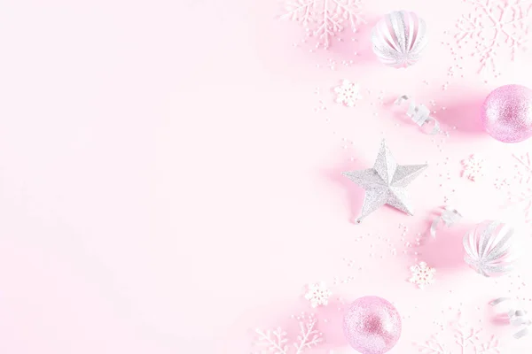 Christmas background concept. Top view of Christmas ball with snowflakes on light pink pastel background.