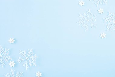 Noel konsepti. Açık mavi pastel arka planda kar taneleri olan Noel balosunun en üst görüntüsü.