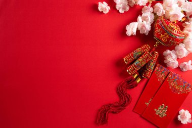 Çin Yeni Yıl Festivali dekorasyonları, kırmızı paket, ipli kraker ve kırmızı arka planda altın külçeler. Çince karakterler Fu makalede servet, servet ve para akışına atıfta bulunuyor..