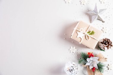 Noel tatilleri kompozisyonu Noel ağacı süslemesi ve beyaz arka planda kırmızı böğürtlenli hediye paketinin en üst görünümü metin alanı ile birlikte.