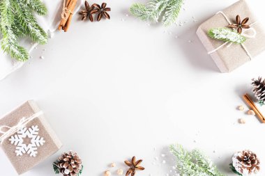 Noel tatilleri kompozisyonu Noel ağacı süslemesi ve beyaz arka planda kırmızı böğürtlenli hediye paketinin en üst görünümü metin alanı ile birlikte.