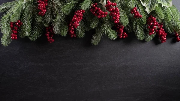 Concepto de fondo de Navidad. Vista superior de la caja de regalo de Navidad bolas rojas con ramas de abeto, conos de pino, bayas rojas y campana sobre fondo de madera negro . —  Fotos de Stock