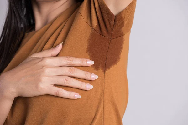 Close-up asian woman with hyperhidrosis sweating. Young asia woman with sweat stain on her clothes against grey background. Healthcare concept. — Stock Photo, Image