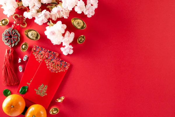 Decorações de festival de ano novo chinês pow ou pacote vermelho, lingotes de laranja e ouro ou caroço de ouro em um fundo vermelho. Personagens chineses FU no artigo referem-se à sorte boa sorte, riqueza, fluxo de dinheiro. — Fotografia de Stock