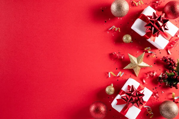 Χριστουγεννιάτικο φόντο. Κορυφή άποψη των Χριστουγέννων κουτί δώρου κόκκινο και χρυσό μπάλα με νιφάδες χιονιού σε ανοιχτό κόκκινο παστέλ φόντο. — Φωτογραφία Αρχείου