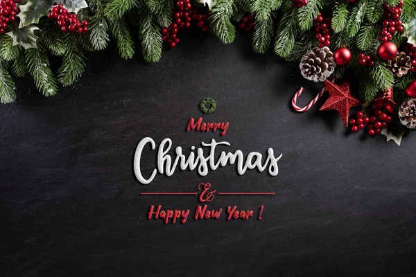 Kerst achtergrond concept. Bovenaanzicht van kerstdoos rode ballen met sparren takken, dennenappels, rode bessen en bel op zwarte houten achtergrond. — Stockfoto