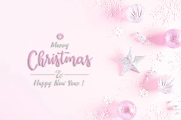 Christmas background concept. Top view of Christmas ball with snowflakes on light pink pastel background.