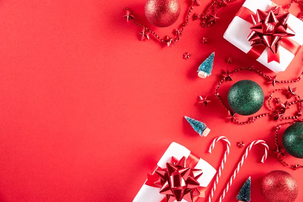 Julbakgrund koncept. Ovanifrån av julklapp box röd och gyllene boll med snöflingor på ljusröd pastell bakgrund. — Stockfoto