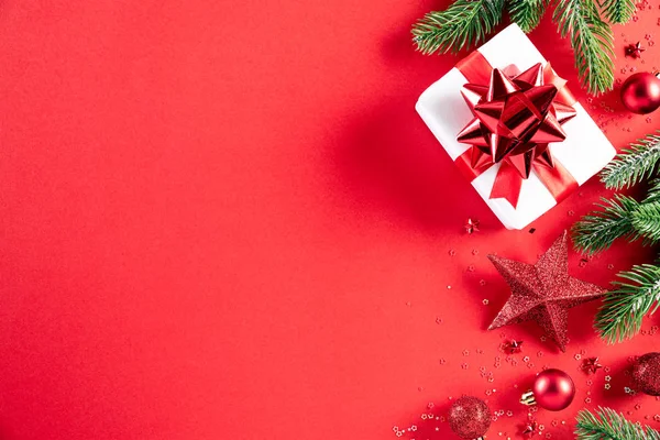 Χριστουγεννιάτικο φόντο. Κορυφή άποψη των Χριστουγέννων κουτί δώρου κόκκινο και χρυσό μπάλα με νιφάδες χιονιού σε ανοιχτό κόκκινο παστέλ φόντο. — Φωτογραφία Αρχείου