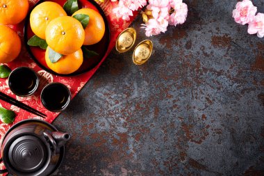 Çin Yeni Yıl Festivali dekorasyonları siyah taş desenli arka planda kırmızı paket, turuncu ve altın külçeler veya altın topak. Çin karakterleri Fu servet, servet, para akışı anlamına gelir..