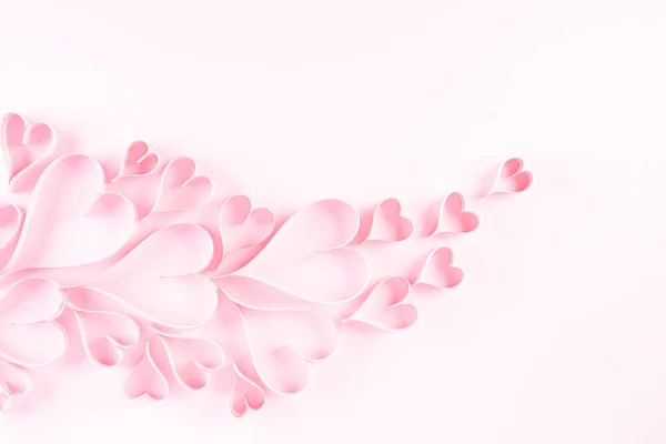 Açık pembe renkli kağıt arka planda pembe kağıt kalpler. Aşk ve Sevgililer Günü konsepti. — Stok fotoğraf