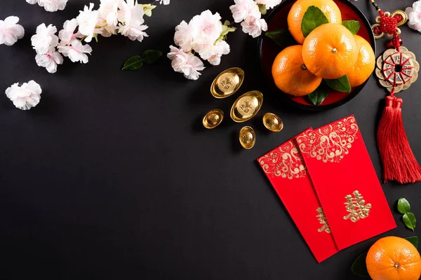 Decoraciones del festival de año nuevo chino pow o paquete rojo, lingotes de naranja y oro o bulto de oro sobre un fondo negro. caracteres chinos FU significa fortuna buena suerte, riqueza, flujo de dinero . — Foto de Stock