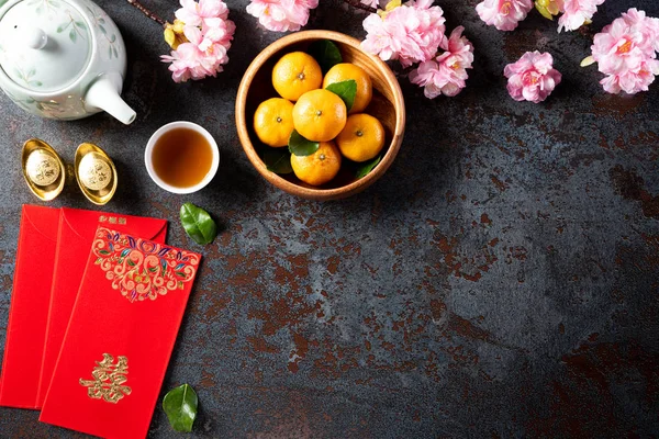 Kinesiska nyår festival dekorationer pow eller rött paket, orange och guld göt eller gyllene klump på en svart sten struktur bakgrund. Kinesiska tecken Fu betyder lycka, rikedom, pengar flöde. — Stockfoto