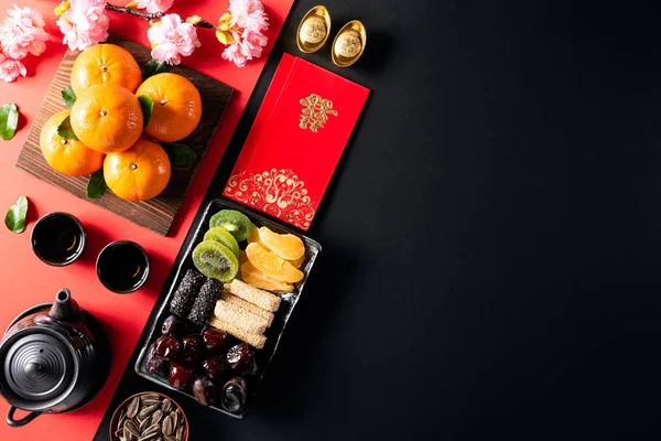 Dekorasi festival tahun baru Tiongkok menanam atau paket merah, ingot oranye dan emas atau benjolan emas di latar belakang hitam. Cina karakter FU berarti keberuntungan keberuntungan, kekayaan, aliran uang . — Stok Foto