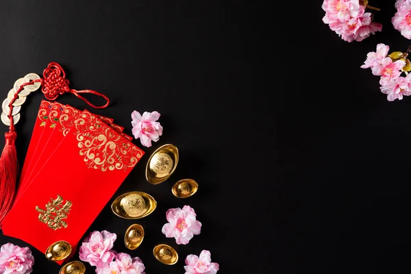 Decoraciones del festival de año nuevo chino pow o paquete rojo, lingotes de naranja y oro o bulto de oro sobre un fondo negro. caracteres chinos FU significa fortuna buena suerte, riqueza, flujo de dinero . — Foto de Stock