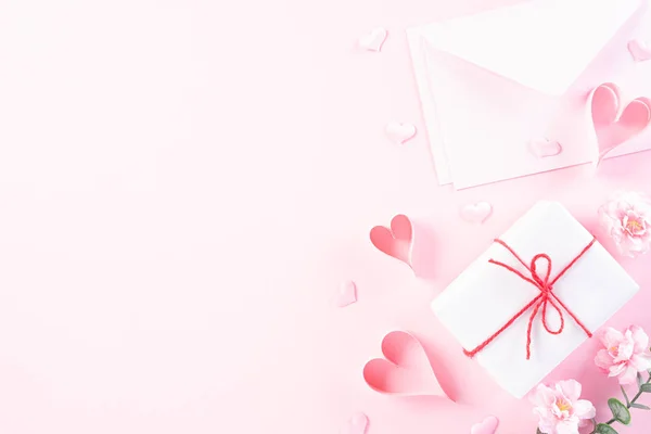 Pink paper hearts with cover letter and gift box on Light pink p — Stock Photo, Image