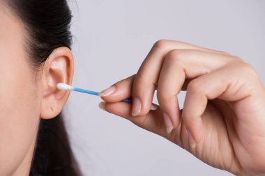 Close up young asian woman cleaning ear with cotton swab. Health