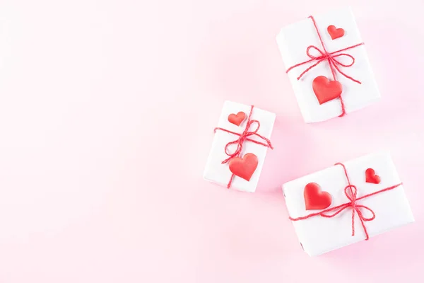 Corazones de papel rosa con caja de regalo en respaldo de papel pastel rosa claro — Foto de Stock