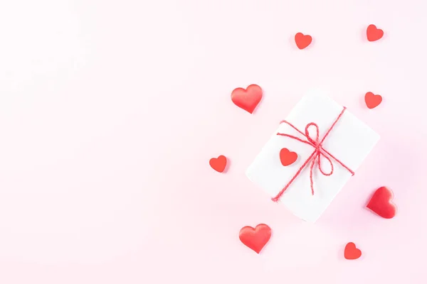 Cuori di carta rosa con scatola regalo su zaino di carta pastello rosa chiaro — Foto Stock
