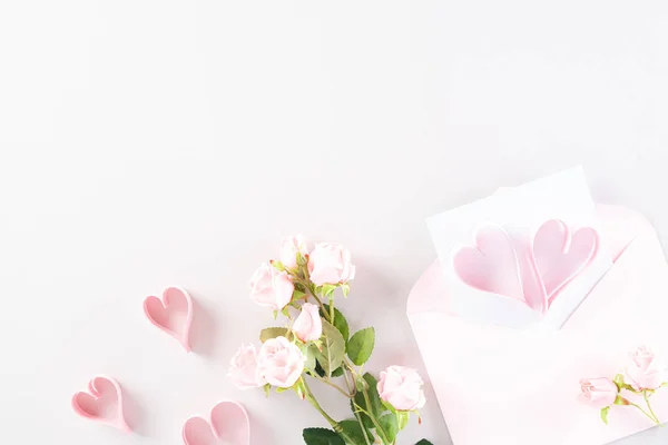 Corações de papel rosa com caixa de presente e rosas no pastel rosa claro p — Fotografia de Stock