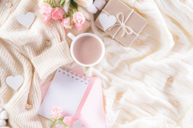 Pink paper hearts with gift box and roses, coffee cup on , beige