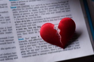 Red broken heart on dictionary love definition. The concept of b