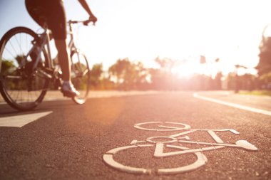 Atletik kadın bisikletçi ile yolda bisiklet logosu görüntüsünü kapat 