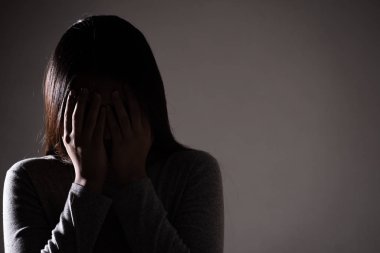 sad woman hug her knee and cry. Sad woman sitting alone in a emp