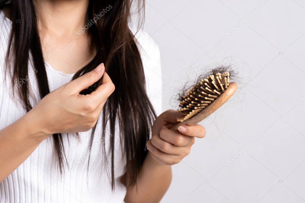 Healthy concept. Woman show her brush with damaged long loss hair and looking at her hair.