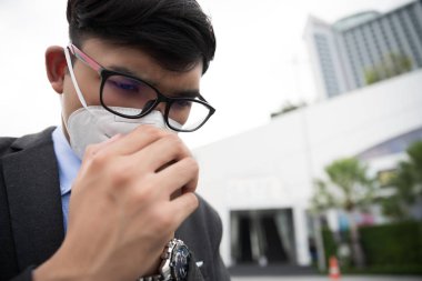 Koruyucu yüz maskesi takan ve öksüren bir iş adamının etrafını sarın. Coronavirus ve 2.5..