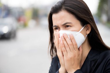 Koruyucu yüz maskesi takan ve öksüren bir iş kadınının etrafını sarın. Coronavirus ve 2.5..