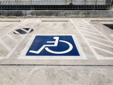 Uluslararası (tekerlekli) özürlü veya sembol otopark devre dışı Park yeri üzerinde parlak mavi boyalı.